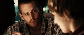 Movie still from “Running Scared” (2006), directed by Wayne Kramer – A person sitting in front of another person; Close Up shot, Over the shoulder angle