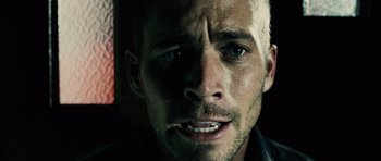 Movie still from “Running Scared” (2006), directed by Wayne Kramer – A man's face in a dark room; Close Up shot, Over the shoulder angle