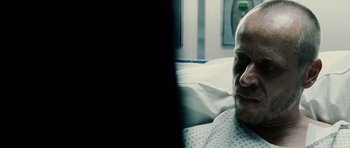 Movie still from “Running Scared” (2006), directed by Wayne Kramer – An older man laying in a hospital bed; Close Up shot, Over the shoulder angle