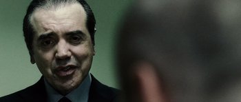 Movie still from “Running Scared” (2006), directed by Wayne Kramer – A person wearing a suit and tie; Close Up shot, Over the shoulder angle