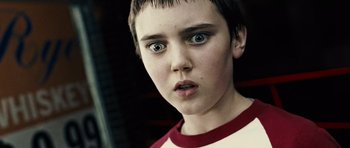 Movie still from “Running Scared” (2006), directed by Wayne Kramer – A young boy with blue eyes stares into the camera; Close Up shot, Low angle