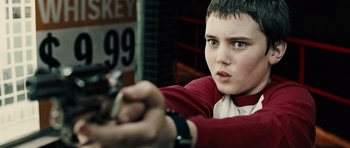 Movie still from “Running Scared” (2006), directed by Wayne Kramer – A young boy holding a gun in his hand; Close Up shot, Low angle