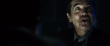 Movie still from “Running Scared” (2006), directed by Wayne Kramer – A person wearing a suit and tie; Close Up shot, Low angle