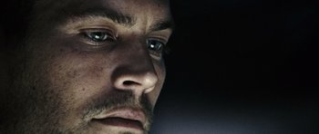 Movie still from “Running Scared” (2006), directed by Wayne Kramer – A man's face in the dark; Extreme Close Up shot, Over the shoulder angle
