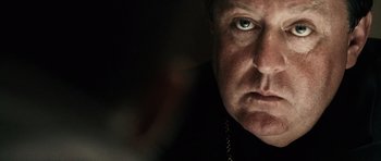 Movie still from “Running Scared” (2006), directed by Wayne Kramer – A man's face in a dark room; Close Up shot, Over the shoulder angle