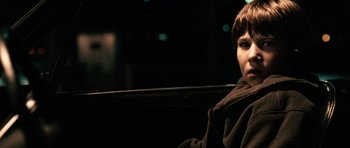 Movie still from “Running Scared” (2006), directed by Wayne Kramer – A young boy sitting on a bench at night; Close Up shot, Over the shoulder angle