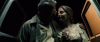 Movie still from “Running Scared” (2006), directed by Wayne Kramer – An older man and a younger woman standing next to each other in the dark; Close Up shot, Over the shoulder angle