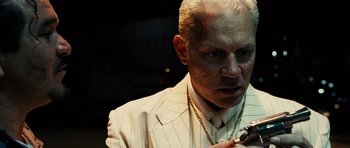 Movie still from “Running Scared” (2006), directed by Wayne Kramer – An older man in a white suit smoking a cigarette; Close Up shot, Over the shoulder angle