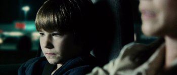 Movie still from “Running Scared” (2006), directed by Wayne Kramer – A young boy sitting in a car seat looking into the distance; Close Up shot, Over the shoulder angle