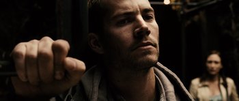 Movie still from “Running Scared” (2006), directed by Wayne Kramer – A person with a beard looking at something; Close Up shot, Over the shoulder angle