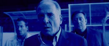 Movie still from “Running Scared” (2006), directed by Wayne Kramer – An older man in a suit and tie; Close Up shot, Low angle