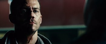 Movie still from “Running Scared” (2006), directed by Wayne Kramer – A man's face in a parking lot; Close Up shot, Over the shoulder angle