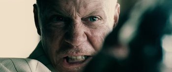 Movie still from “Running Scared” (2006), directed by Wayne Kramer – An old man with a bald head and blue eyes; Extreme Close Up shot, Low angle
