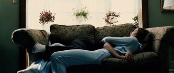 Movie still from “Running Scared” (2006), directed by Wayne Kramer – A person laying on a couch with their legs crossed; Medium shot, Low angle