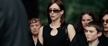 Movie still from “Running Scared” (2006), directed by Wayne Kramer – A woman in a black dress wearing sunglasses; Medium shot, Over the shoulder angle