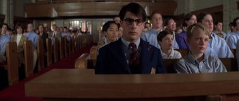 Movie still from “Rushmore” (1998), directed by Wes Anderson – A group of people sitting in a room; Medium shot, Low angle
