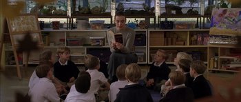 Movie still from “Rushmore” (1998), directed by Wes Anderson – A woman reading a book to a group of children; Medium shot, High angle