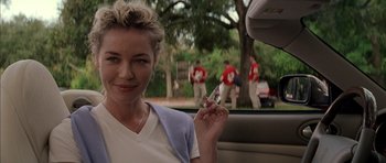 Movie still from “Rushmore” (1998), directed by Wes Anderson – A woman sitting in the back of a car holding a cigarette; Close Up shot, Over the shoulder angle