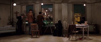 Movie still from “Rushmore” (1998), directed by Wes Anderson – A woman sitting in front of a window with a camera; Wide shot, High angle