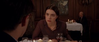 Movie still from “Rushmore” (1998), directed by Wes Anderson – A woman sitting at a dinner table with candles; Close Up shot, Over the shoulder angle