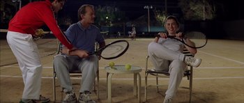 Movie still from “Rushmore” (1998), directed by Wes Anderson – Two men sitting on chairs holding tennis rackets; Medium shot, Low angle