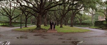 Movie still from “Rushmore” (1998), directed by Wes Anderson – A man and a woman are walking through a park; Wide shot, Low angle