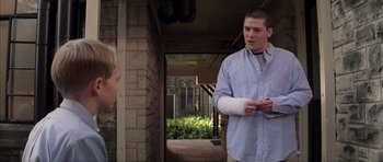 Movie still from “Rushmore” (1998), directed by Wes Anderson – A man with a cast on his arm talking to a woman; Medium shot, Over the shoulder angle