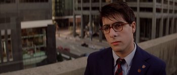 Movie still from “Rushmore” (1998), directed by Wes Anderson – A man in a suit and glasses is looking at the camera; Close Up shot, Low angle