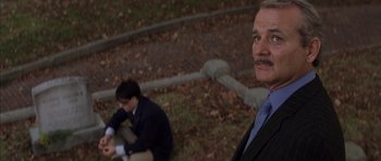 Movie still from “Rushmore” (1998), directed by Wes Anderson – A man in a suit and tie standing next to another man in a suit and tie; Medium shot, Low angle