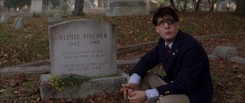 Movie still from “Rushmore” (1998), directed by Wes Anderson – A man sitting in front of a grave in a cemetery; Medium shot, Over the shoulder angle