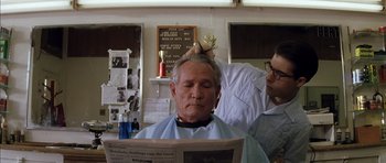 Movie still from “Rushmore” (1998), directed by Wes Anderson – An older man getting his hair cut at a barber shop; Close Up shot, Low angle