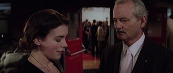 Movie still from “Rushmore” (1998), directed by Wes Anderson – A man and a woman standing next to each other in a room; Close Up shot, Over the shoulder angle