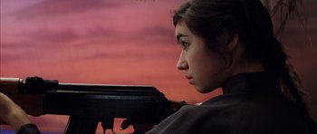 Movie still from “Rushmore” (1998), directed by Wes Anderson – A woman is holding a gun in her hands; Close Up shot, Low angle