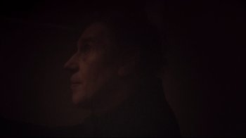 Movie still from “Russian Ark” (2002), directed by Aleksandr Sokurov – A man is looking into the distance in the dark; Close Up shot, Low angle