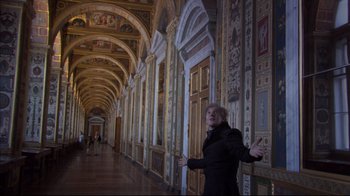 Movie still from “Russian Ark” (2002), directed by Aleksandr Sokurov – A woman standing in front of a wall with many doors; Wide shot, Low angle