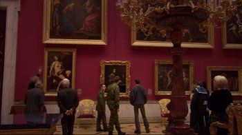 Movie still from “Russian Ark” (2002), directed by Aleksandr Sokurov – A group of people standing in front of a wall of paintings; Wide shot, High angle