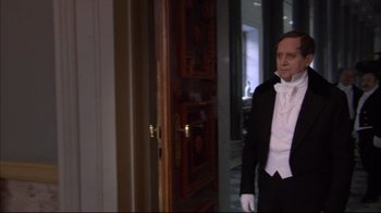 Movie still from “Russian Ark” (2002), directed by Aleksandr Sokurov – A man in a tuxedo standing in front of a door; Medium shot, Over the shoulder angle
