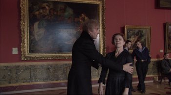 Movie still from “Russian Ark” (2002), directed by Aleksandr Sokurov – A man and a woman in a room with paintings on the wall; Medium shot, Over the shoulder angle