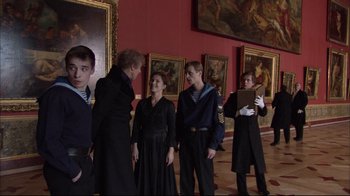 Movie still from “Russian Ark” (2002), directed by Aleksandr Sokurov – A group of people standing in front of paintings; Medium shot, Over the shoulder angle