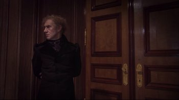 Movie still from “Russian Ark” (2002), directed by Aleksandr Sokurov – A man standing in front of a wooden door; Medium shot, Over the shoulder angle