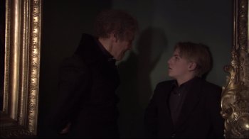 Movie still from “Russian Ark” (2002), directed by Aleksandr Sokurov – Two people are facing each other in a dark room; Medium shot, Over the shoulder angle