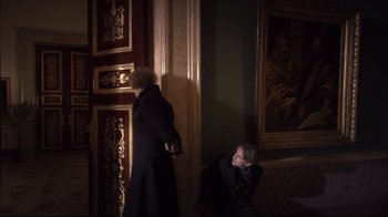 Movie still from “Russian Ark” (2002), directed by Aleksandr Sokurov – A man in a black coat and a woman in a black dress; Wide shot, Over the shoulder angle