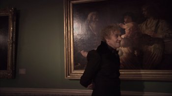 Movie still from “Russian Ark” (2002), directed by Aleksandr Sokurov – An older woman standing in front of a painting; Medium shot, Over the shoulder angle