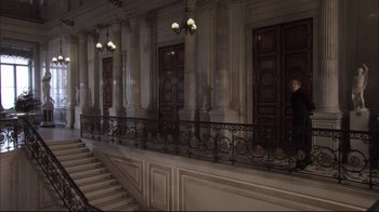 Movie still from “Russian Ark” (2002), directed by Aleksandr Sokurov – A staircase in a large room with white walls and pillars; Extreme Wide shot, Low angle