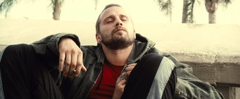 Movie still from “Rust and Bone” (2012), directed by Jacques Audiard – A person laying on the ground with his eyes closed; Close Up shot, High angle