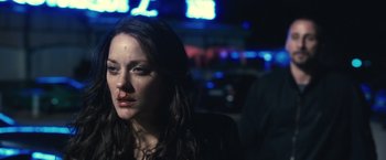 Movie still from “Rust and Bone” (2012), directed by Jacques Audiard – A woman with a bruised face sitting in a dark room at night; Close Up shot, Over the shoulder angle