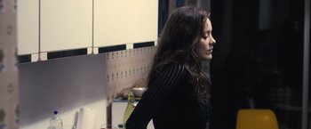 Movie still from “Rust and Bone” (2012), directed by Jacques Audiard – A woman standing in a kitchen with her hair blowing in the wind; Medium shot, Over the shoulder angle