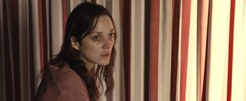 Movie still from “Rust and Bone” (2012), directed by Jacques Audiard – A woman with long brown hair stares into the distance; Close Up shot, Over the shoulder angle