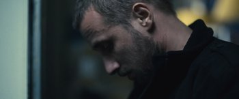 Movie still from “Rust and Bone” (2012), directed by Jacques Audiard – A person's face in a dark room; Close Up shot, Low angle