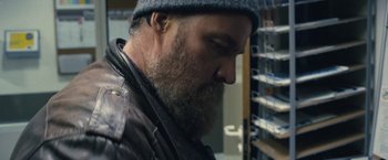 Movie still from “Rust and Bone” (2012), directed by Jacques Audiard – A man with a beard wearing a hat and jacket; Close Up shot, Low angle